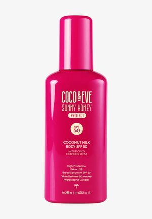 Lait Corporel à la Noix de Coco SPF 50 dans une bouteille en plastique rose vif à forme arrondie. Dispose d'une pompe et d'un texte blanc indiquant les détails du produit.