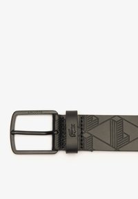 Cintura in pelle nera con motivo geometrico, dotata di una fibbia metallica rettangolare incisa con "LACOSTE" e un logo in rilievo.