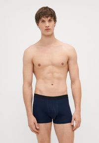 Marineblaue Boxershorts mit einem schwarzen elastischen Bund, enganliegendem Design und weich strukturiertem Baumwollmaterial. Keine Muster oder Akzente.