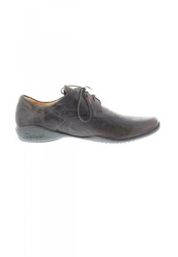 Braune Lederschuhe mit runder Zehenpartie, Schnürverschluss, dezenten Nähten und einer flexiblen Sohle, die eine strukturierte Oberfläche und minimale Akzente aufweist.