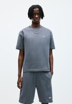 Set di felpa e pantaloni corti in cotone grigio misto con colletto a girocollo, maniche corte e dettaglio del logo. Presenta una vestibilità comoda e una texture morbida.