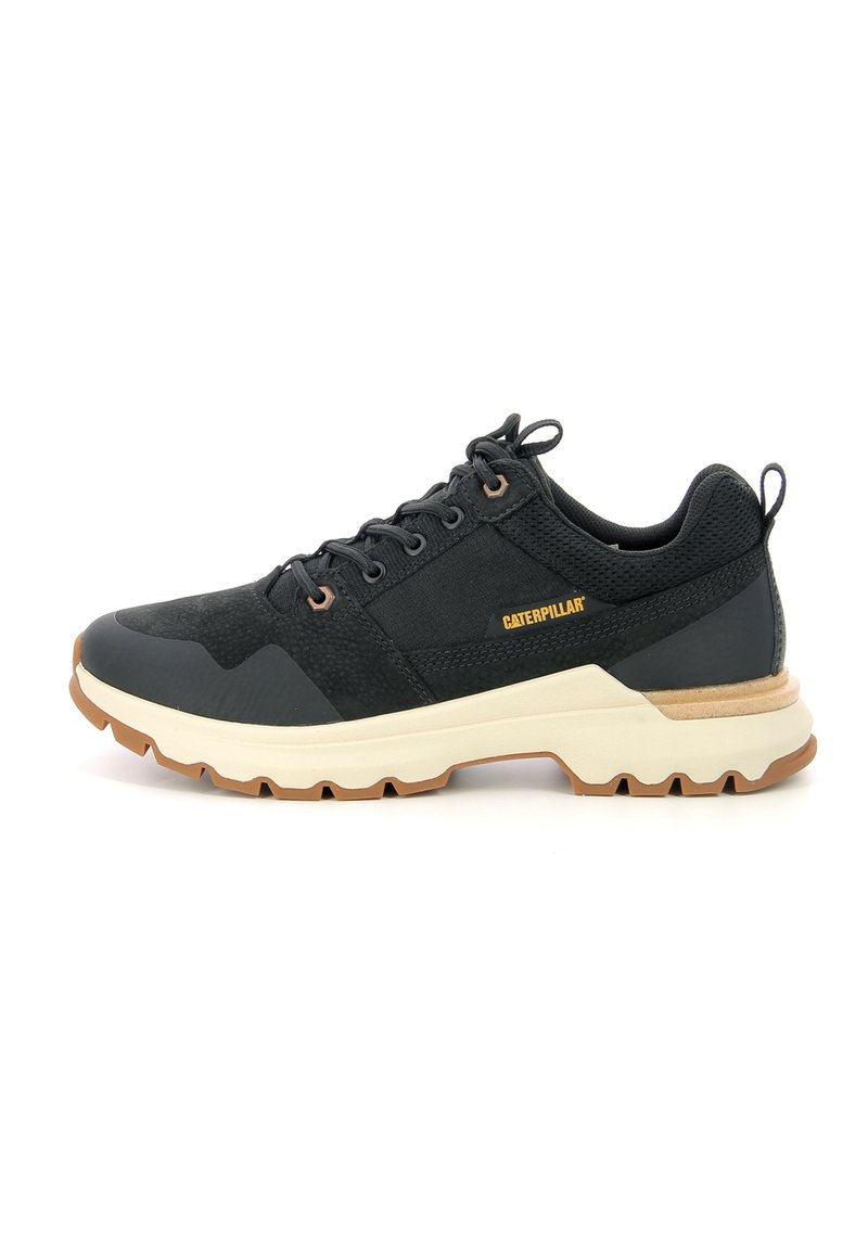 Zapatilla deportiva negra con parte superior de malla texturizada, talón reforzado, entresuela beige y suela de goma con un patrón de banda de rodadura distintivo.
