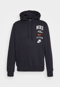Svart hoodie i bomullsblandning med en känguruficka, dragsko på huvan och flera Nike-logotyper i vitt och orange.