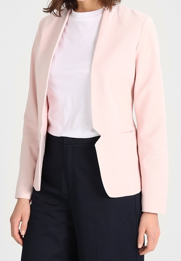 Růžový blazer v hladké tkanině s minimalistickým designem, s dlouhými rukávy, otevřeným předním dílem a dvěma předními kapsami. V kombinaci s bílou košilí.