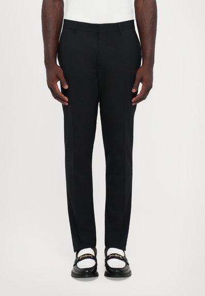 Schwarze, maßgeschneiderte Hosen mit schmaler Passform, aus glattem Stoff gefertigt. Verfügt über Seitentaschen und ein glattes Vorderdesign. Die Hose hat eine Bügelfalte entlang des Beins.
