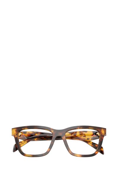 Occhiali da vista in acetato tartarugato con forma rettangolare, aste larghe e una texture liscia. Lenti trasparenti, montatura robusta e moderna.