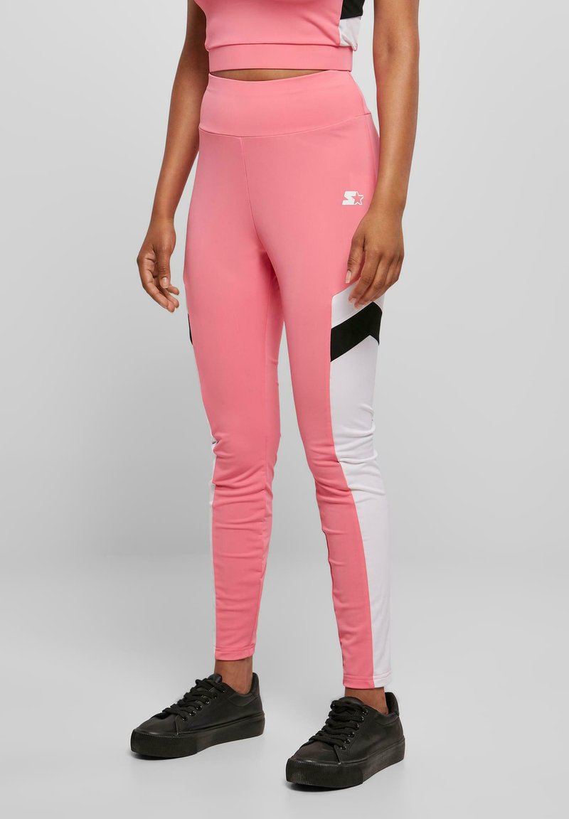 Rosa leggings med hvite og svarte sidepaneler, høy midje, glatt stoff og tettsittende design. Logo synlig på låret.