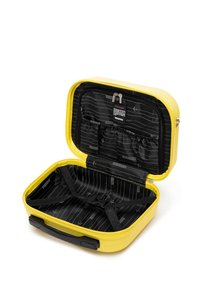 Funda rígida amarilla con interior forrado en negro. Incluye compartimentos y correas elásticas para la organización. Cierre de doble cremallera.
