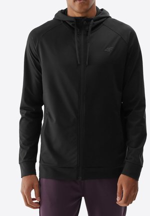 Sudadera negra con cremallera y cuello alto, mangas largas y logo tonal en el pecho. Fabricada con un tejido suave y elástico. Cuenta con cordones ajustables.