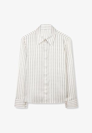 Hvid bluse med lange ærmer og sorte lodrette striber, spidst krave, og knaplukning ved ærmekanter, lagt fladt på en hvid baggrund.