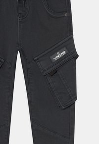 Svarta denim cargobyxor med en sidoficka, som har en etikett och detaljstickningar, slät textur och en figurformad design.