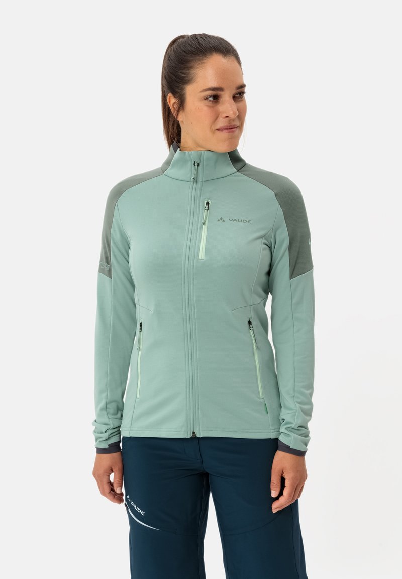 Hellgrüne Zip-Jacke mit hohem Kragen, mit grauen Akzenten auf den Schultern, einem mit Reißverschluss versehenen Brusttasche und Seitentaschen. Glatte Textur.