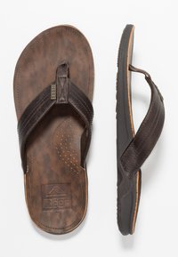 Infradito in pelle marrone con superficie texturizzata e plantare perforato. Presentano una fascia a soffietto con logo e suola in gomma.