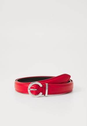 Red leather belt with a smooth finish, featuring a silver circular buckle and a sleek design. The interior is black.