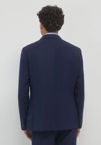 Dunkelblau gestreifter Anzugjacke, taillierte Passform, mit Reverskragen und geknöpften Ärmeln. Glatte Stoffstruktur, klare Linien und minimale Details.