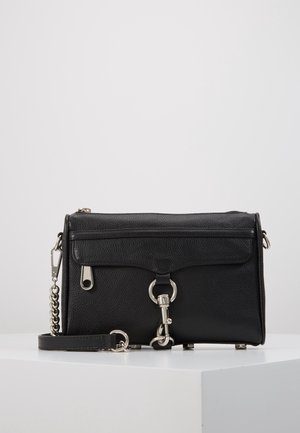 Zwarte textuurlederen crossbodytas met zilverkleurige hardware, voorflapzak, ritssluiting en een kettingriem liggend op een witte ondergrond.