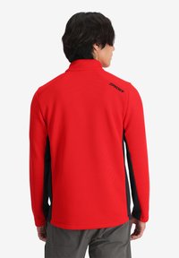 Pullover rosso a maniche lunghe realizzato in un tessuto strutturato. Presenta pannelli laterali neri e un colletto alto. Logo sul retro vicino al colletto.