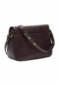 Ciemnoczerwono-burgundowa skórzana torebka o jasno określonym kształcie, z regulowanym paskiem i mosiężnymi detalami. Czyste linie i gładka tekstura.