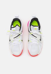 Zapatilla blanca con acentos en negro y verde neón, parte superior de malla texturizada, cuello acolchado y suela rosa. Presenta cordones contrastantes y un logotipo.