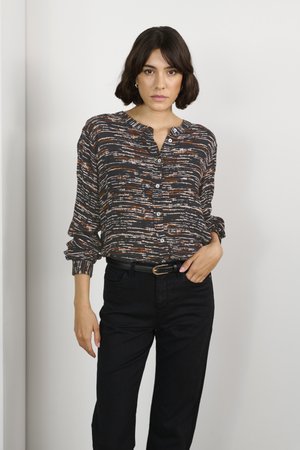 Zwarte geprinte overhemden met een meerkleurig penseelstrekenontwerp, lichtgewicht stof, lange mouwen en een kraag. Gekozen met donkerblauwe jeans.