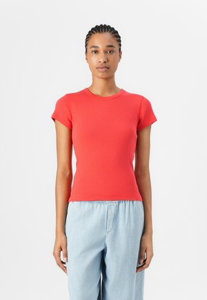 T-shirt ajusté rouge à rayures, à manches courtes et col rond, associé à un pantalon léger bleu clair à taille élastique. Design simple et sans couture.