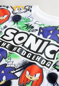 Sonic the Hedgehog Grafik-Sweatshirt in Weiß, mit bunten Charakterdrucken und schwarzem Logotext, aus einem glatten Baumwollmaterial.