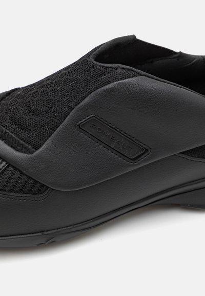 Chausson noir avec dessus en maille texturée et accents en cuir lisse. Comprend un logo et une semelle extérieure en caoutchouc flexible pour un confort optimal.