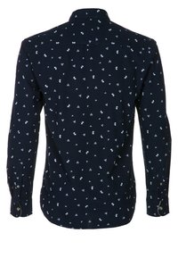 Marinblus med långa ärmar och knappad krage, med små vita geometriska och blommiga mönster över hela.