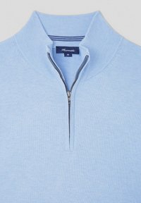 Jasnoniebieski sweter z zamkiem na suwak z prążkowanym kołnierzem i fakturą. Posiada prostą sylwetkę oraz zamek błyskawiczny przy szyi.