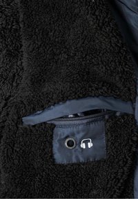 Czarna, teksturowana polarowa podszewka kurtki z zamkiem błyskawicznym, z kieszenią z gniazdem na słuchawki i logo. Podszewka ma gładką fakturę.