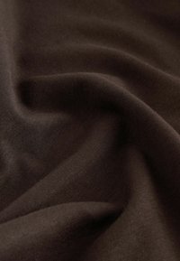 Dunkelbrauner Stoff mit einer glatten, weichen Textur, in Falten gezeigt, wodurch sein Fall und der gleichmäßige Farbton ohne Muster oder sichtbare Beschläge hervorgehoben werden.