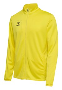 Gul zip-up jakke lavet af let, glat stof. Har høj krave, lange ærmer og et lille sort logo på brystet.