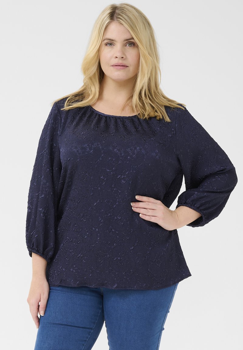 Blusa blu navy con un motivo testurizzato, scollatura tonda e maniche a tre quarti, con dettagli arricciati alla scollatura.