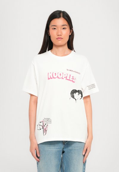 Fehér pamut póló, rózsaszín "KOOPLES" logóval, egy pár és egy kutya grafikus ábrázolásaival, szöveges részletekkel az elülső és a side részen.