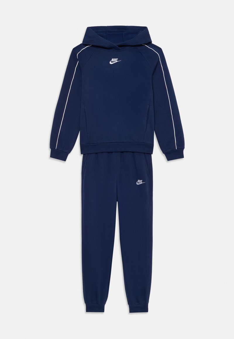 Fato de treino azul-marinho com uma sweatshirt com capuz e calças combinando, apresentando detalhes brancos e um pequeno logótipo no peito e na coxa.