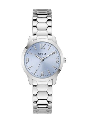 Montre-bracelet à maillons en métal argenté avec cadran bleu, index argentés et trois aiguilles indiquant 10:10:37, avec le logo GUESS sur le cadran.