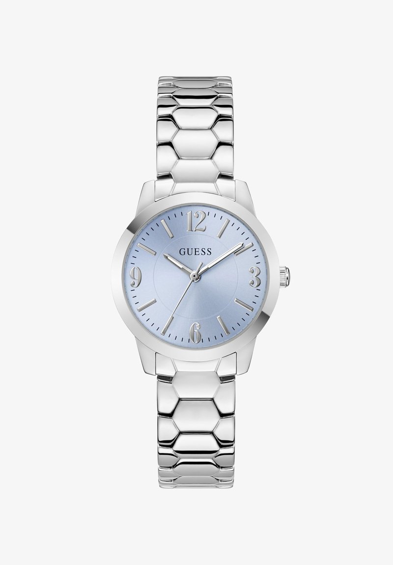 Montre-bracelet à maillons en métal argenté avec cadran bleu, index argentés et trois aiguilles indiquant 10:10:37, avec le logo GUESS sur le cadran.