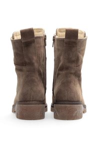 Stivali ankle in suede marrone con superficie testurizzata, zip laterali e suola in gomma spessa. Presentano linguette sulla parte superiore per una facile calzata.