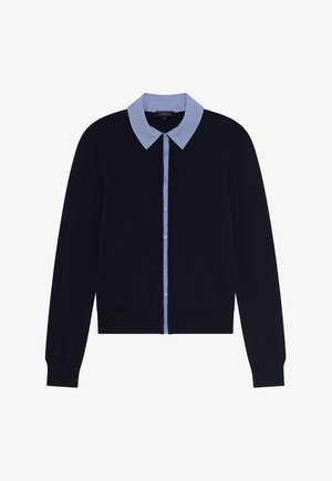 Donkerblauwe cardigan met een lichtblauw overhemd eronder. Voorzien van een knoopsluiting en lange mouwen. Zachte textuur, klassiek ontwerp.