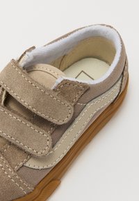 Baskets à velcro en daim brun clair et toile, avec une bande latérale en cuir beige, un col rembourré et une semelle extérieure en caoutchouc naturel.