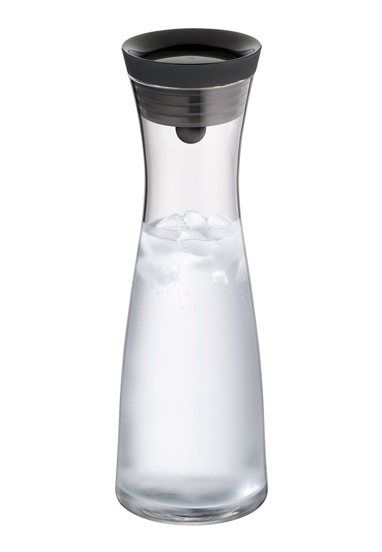 Przezroczysta szklana karafka o smukłym, zakrzywionym kształcie. Czarna, okrągła pokrywka z wylewką. Zawiera przezroczystą wodę z kostkami lodu.