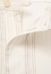 Tissu beige clair avec de fines rayures verticales grises, doté d'une fermeture à boutons et d'une fermeture éclair, mettant en avant une texture douce et un design ajusté.