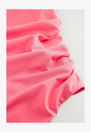 Svijetloružičasta tkanina glatke teksture, s mekim naborima i slabo elastičnom kvalitetom, idealna za odjeću ili dodatke.