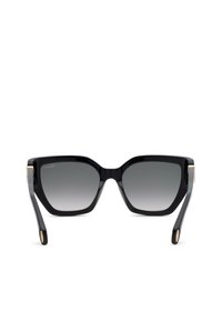 Lunettes de soleil carrées noires oversize avec des montures épaisses et des verres foncés dégradés, présentées de face sur fond blanc.