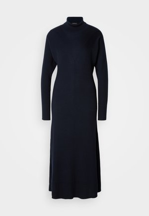 Robe en tricot côtelé bleu marine, à col montant avec des manches longues et des fentes latérales. Dispose d'un corsage ajusté et d'une jupe fluide.