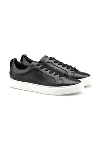 Sneaker in pelle nera con una texture liscia, suola in gomma bianca, punta rotonda e lacci piatti. Presenta un marchio sul lato e un design a punta bassa.
