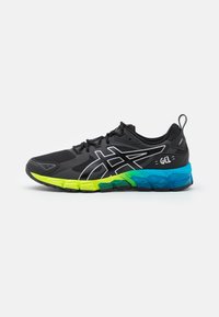 Scarpa sportiva nera con una tomaia testurizzata, dettagli in argento e una suola multicolore in verde, blu e nero. Presenta un design con lacci.