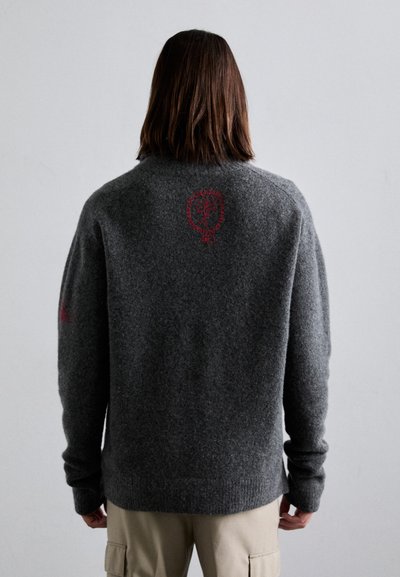 Grauer Strickpullover aus Wolle mit einem grafischen roten Design auf dem Rücken sowie gerippten Bündchen und Saum. Glatte Textur, lässige Passform.