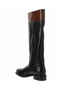 Bota de cuero negro hasta la rodilla con acabado suave, puño de cuero marrón, cremallera lateral y tacón bajo apilado.