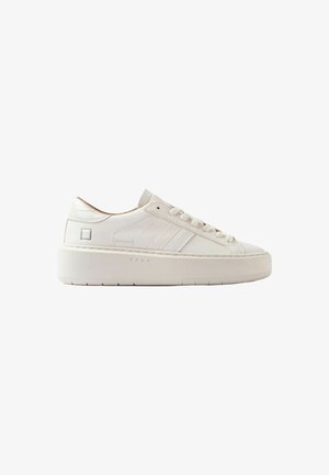 Sneaker en cuir blanc à tige basse avec semelle épaisse, coutures sur les côtés et fermeture à lacets sur fond blanc uni.